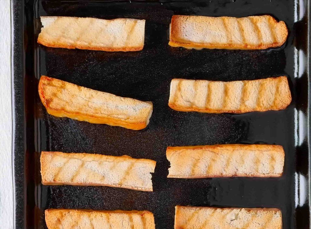 Crispy and Irresistible Frozen French Toast Sticks in Air Fryer 14 Frozen French toast sticks being placed in an air fryer basket, ready for cooking.